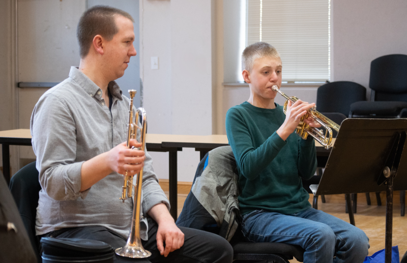 student playing the trumpet with a private teacher