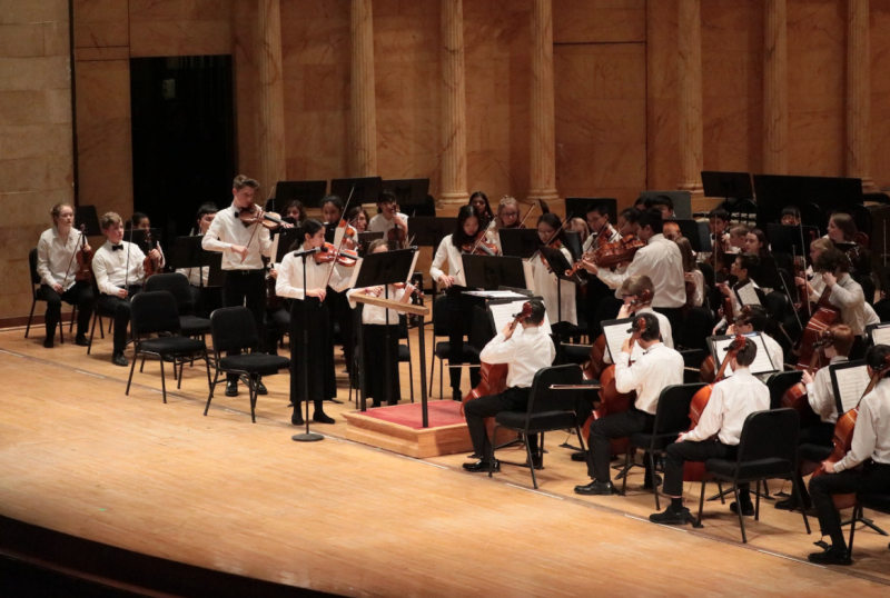 teacher helping student to play violin